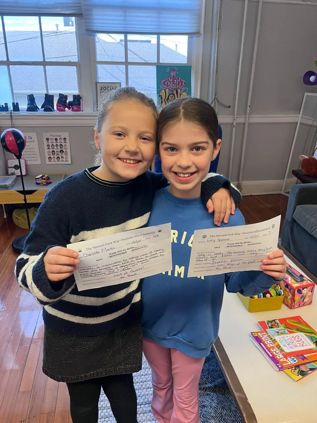 Two students holding papers